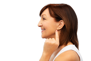 Image showing smiling senior woman pointing to her earring