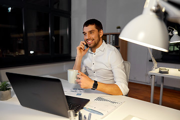 Image showing businessman calling on smartphone at night office