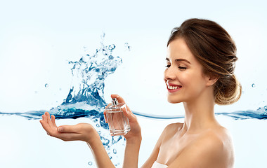 Image showing happy woman with perfume over water splash