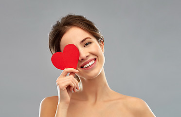 Image showing beautiful smiling woman holding red heart