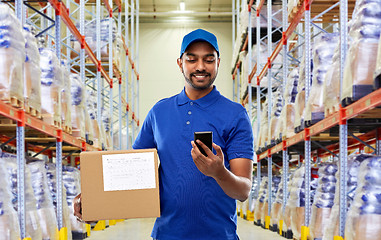 Image showing delivery man with smartphone and box at warehouse
