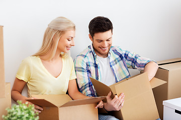 Image showing happy couple unpacking boxes at new home