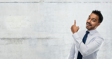 Image showing indian businessman pointing finger at wall