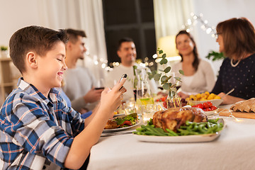 Image showing boy with smartphone at family dinner party