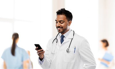 Image showing smiling indian male doctor with smartphone