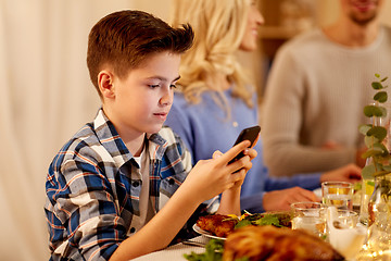 Image showing boy with smartphone at family dinner party