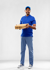 Image showing happy indian delivery man with pizza boxes in blue