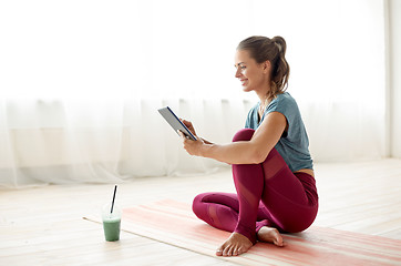 Image showing woman with tablet pc and drink at yoga studio
