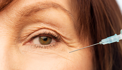 Image showing close up of senior woman face and syringe