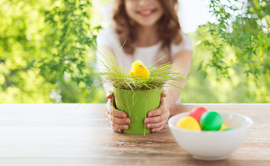 Image showing close up of girl with toy chicken in flowerpot