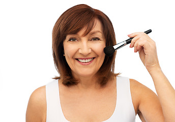 Image showing smiling senior woman with make up blush brush