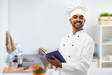 Image showing happy male indian chef with cookbook at kitchen