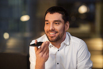 Image showing businessman recording voice message on smartphone