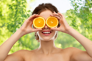 Image showing smiling woman with oranges over grey background