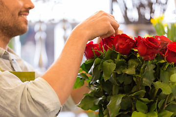 Image showing florist or seller setting red roses at flower shop