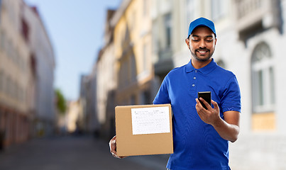 Image showing delivery man with smartphone and parcel in city