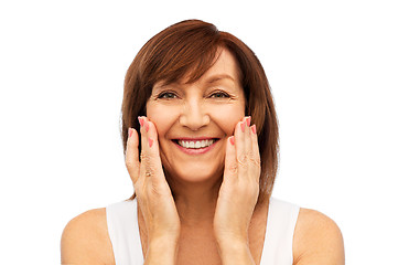 Image showing portrait of smiling senior woman touching her face