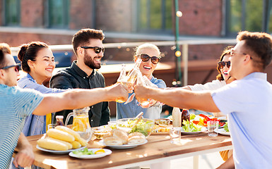 Image showing happy friends toasting drinks at rooftop party