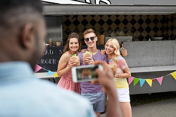 Image showing man taking picture of friends eating at food truck