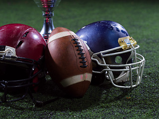 Image showing closeup of american football,helmets and trophy