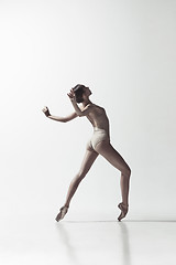 Image showing Ballerina. Young graceful female ballet dancer dancing isolated on white. Beauty of classic ballet.