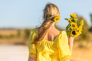 Image showing Female holding bunch of beautiful sunflowers in rural landscape