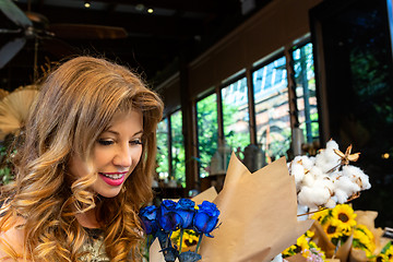 Image showing Customer buying or admiring a bunch of blue roses