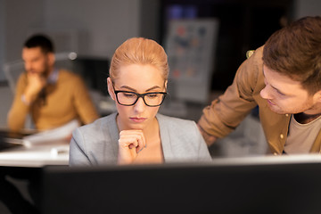 Image showing business team with computer working late at office