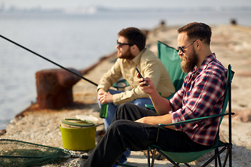 Image showing friends with smartphone and beer fishing on pier