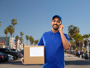 Image showing indian delivery man with smartphone and parcel box