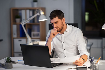 Image showing businessman with laptop working at night office