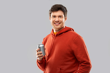 Image showing happy young man drinking soda from tin can