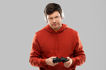 Image showing displeased man with gamepad playing video game