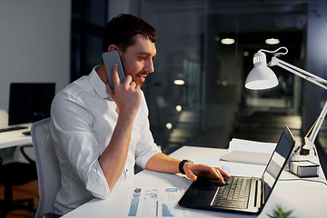 Image showing businessman calling on smartphone at night office