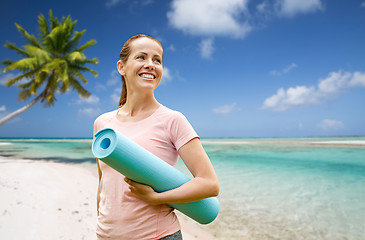 Image showing happy smiling woman with exercise mat over beach