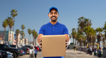 Image showing happy indian delivery man with parcel box in blue