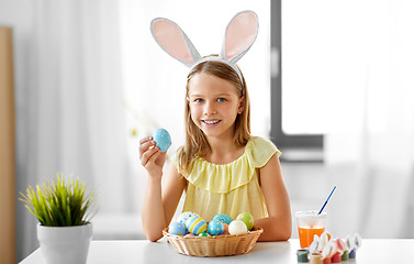 Image showing happy girl with colored easter eggs at home