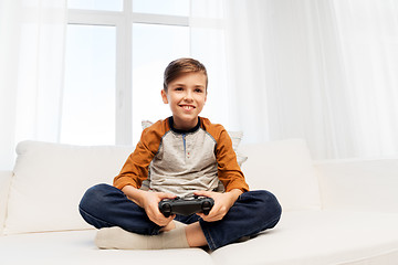 Image showing happy boy with gamepad playing video game at home