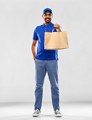 Image showing happy indian delivery man with food in paper bag