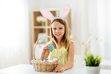 Image showing happy girl with colored easter eggs at home