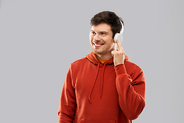 Image showing happy young man in headphones and red hoodie