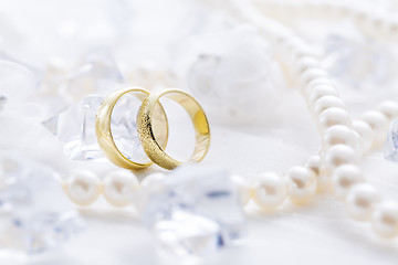 Image showing Two golden rings with pearl necklace and on white background