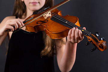 Image showing Close up of professional violin in hands of little violinist playing it