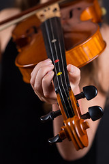 Image showing Close up of professional violin in hands of little violinist playing it