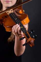 Image showing Close up of professional violin in hands of little violinist playing it