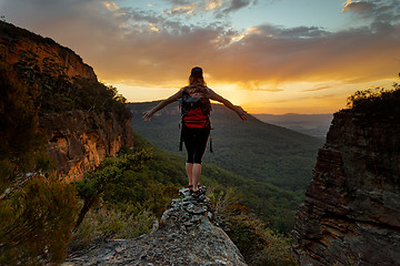 Image showing Hiker standing firm on narrow ledge  in wilderness mountains