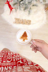 Image showing Festive woman holding cappuccino with Christmas design