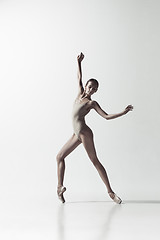 Image showing Ballerina. Young graceful female ballet dancer dancing isolated on white. Beauty of classic ballet.