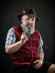 Image showing dramatic portrait of senior smoking tobacco pipe