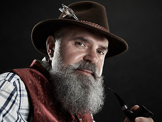 Image showing dramatic portrait of senior smoking tobacco pipe